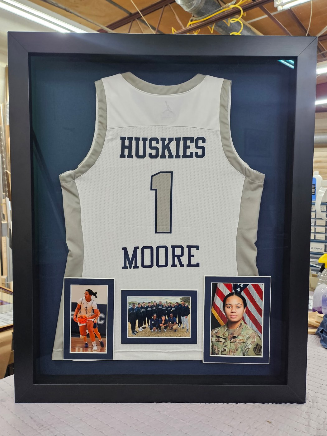 Basketball jersey and photographs mounted in a custom navy shadowbox